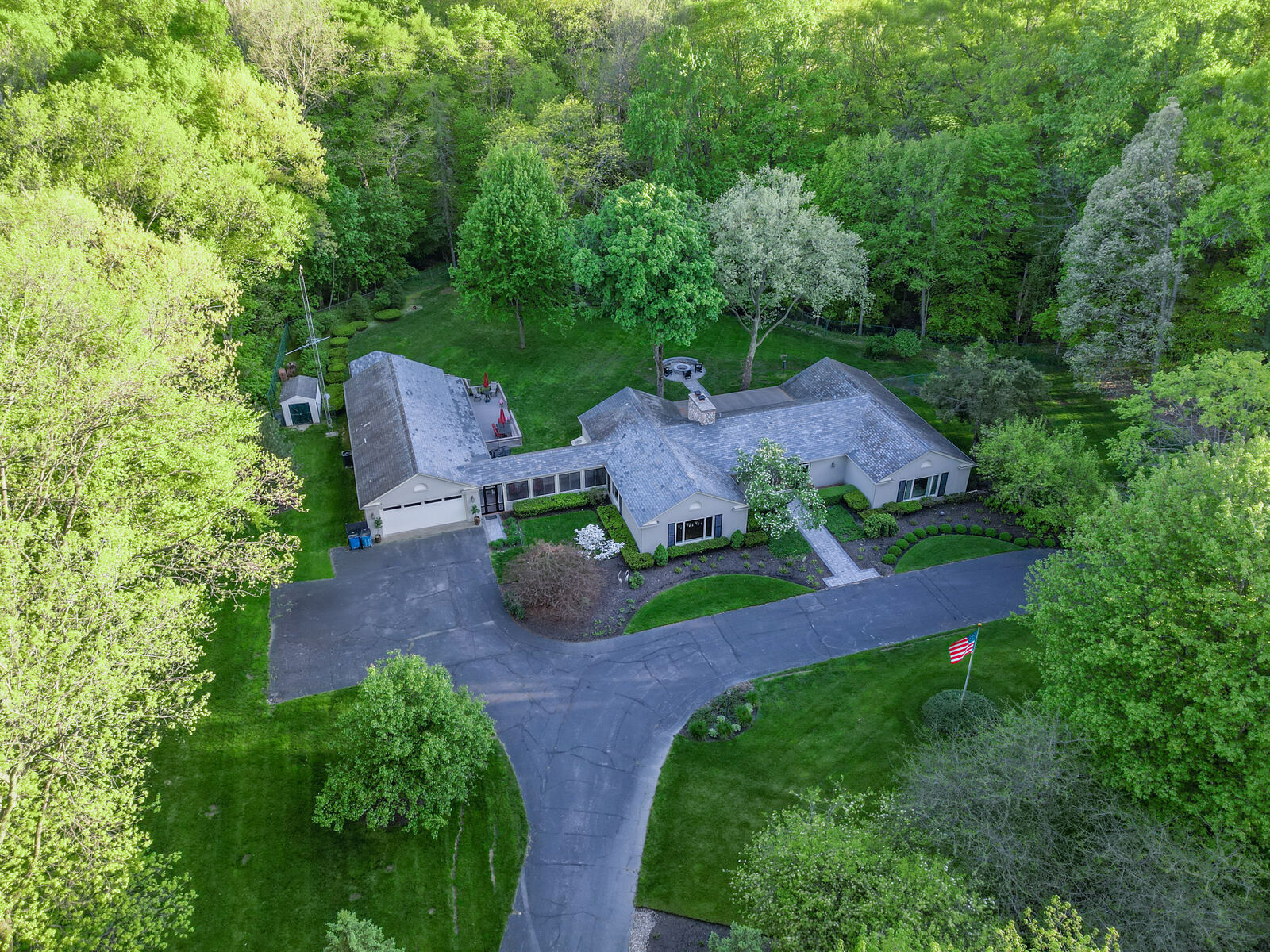 Aerial photo of a home with long driveway and wooded lot